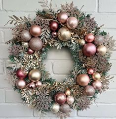 a christmas wreath hanging on a brick wall with ornaments in the shape of an ornament