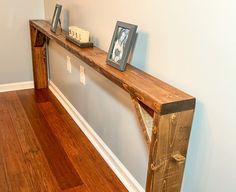 a wooden shelf sitting on top of a hard wood floor next to a white wall