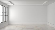 an empty room with white walls and windows