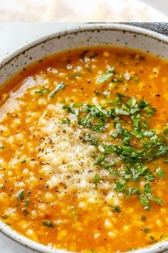 a white bowl filled with soup and garnished with parmesan cheese on top