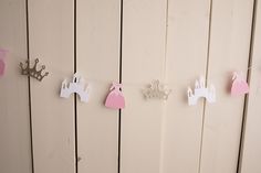 paper princess crowns hanging from clothesline on wall