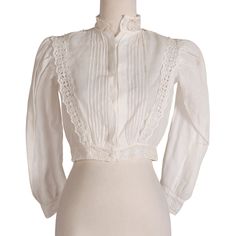 Cutesy white blouse with eyelet pattern at sleeve cuffs, hem, and down the torso. Material is sheer and light.  Measurements Bust: 36" Waist: 28" Length: 14.5" Shoulder-to-Shoulder: 13" Sleeve Length: 22" Condition: Good; some stains (See images) This has not been stain treated by us. Classic Fitted Blouse With Sheer Sleeves, Classic Blouse With Sheer Sleeves And Fitted Design, White Fitted Blouse With Lace Sleeves, Classic White Top With Lace Sleeves, White Formal Tops With Sheer Sleeves, White Formal Top With Sheer Sleeves, White Sheer Sleeves Top For Formal Occasions, Formal White Tops With Sheer Sleeves, White Fitted Blouse With Sheer Sleeves