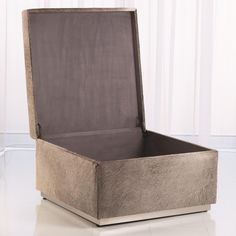 an open box sitting on the floor in front of a white wall with curtains behind it