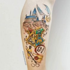 a harry potter tattoo with hogwart's castle in the background and symbols around it