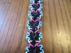 two rows of multicolored bracelets sitting on top of a wooden table