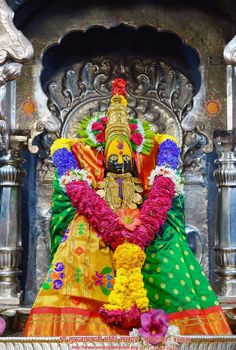 the statue is decorated with flowers and garlands