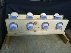 a wooden rack with six cups on it