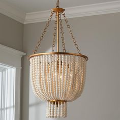 a chandelier with beads hanging from it's ceiling in a home setting