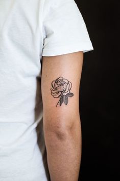 a woman's arm with a rose tattoo on the left side of her arm