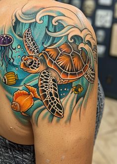 a woman with a tattoo on her shoulder has a turtle and jellyfish in the ocean