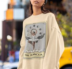 The Dancer Tarot Card Sweatshirt, Dancer Sweatshirt, Ballerina Sweater Ballet Dancer Gifts .: 50% cotton, 50% polyester .: Medium-heavy fabric (8.0 oz/yd² (271.25 g/m .: Loose fit .: Runs true to size Graphic Print Crew Neck Sweatshirt For Dance, Crew Neck Graphic Print Sweatshirt For Dance, Cotton Graphic Print Sweatshirt For Dance, Long Sleeve Cotton T-shirt For Dance Class, Long Sleeve Graphic T-shirt For Dance, Long Sleeve Graphic Print T-shirt For Dance, Graphic Print Long Sleeve Sweatshirt For Dance, Long Sleeve Cotton T-shirt For Dance, Graphic Print Long Sleeve Tops For Dance