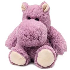 a purple stuffed animal sitting up against a white background