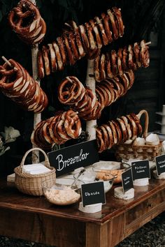 an assortment of pretzels and breads on display for sale at a market