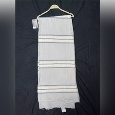 a white and blue striped towel hanging on a hanger with a tag attached to it