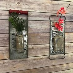 two metal wall hangings with flowers and vases on them against a wooden wall