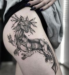 a black and white photo of a woman's thigh with a horse tattoo on it