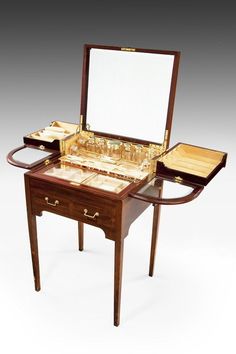 a wooden table with an open drawer and mirror on it's top, in front of a white background