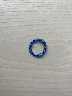 This ocean-inspired ring is made with a mix of different sized and colored blue beads. Perfect for the summer and to accessorize with our other beaded products. Made with stretchy cord, one size fits most. For a more personalized fit, message your ring size to me! Blue Stackable Jewelry With Round Beads, Blue Stackable Jewelry For The Beach, Casual Blue Beaded Jewelry, Blue Spacer Beads Jewelry For The Beach, Casual Blue Round Beads Jewelry, Casual Blue Round Beaded Jewelry, Blue Letter Beads For Gifts, Blue Faceted Beads Casual Style, Blue Beads For Jewelry Making