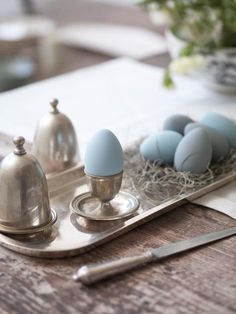 some blue eggs are sitting on a tray