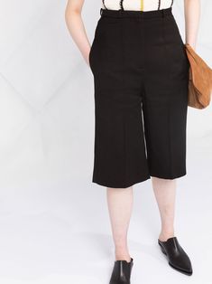 Black silk blend cropped tailored trousers from TOTEME featuring tonal design, front button and zip fastening, belt loops, two side slit pockets, straight leg, cropped leg and pressed crease. Conscious: We've partnered with Good On You – an ethical agency that rates how sustainably brands perform. This item comes from a brand that performs well in relation to their impact on people, which ensures good working conditions in the supply chain.. | Totême Cropped Tailored Trousers Suit Shorts, Leg Press, Supply Chain, Tailored Trousers, Black Silk, Straight Leg, Trousers, Brand New, Silk