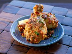 a blue plate topped with two pieces of chicken covered in sauce and parmesan cheese