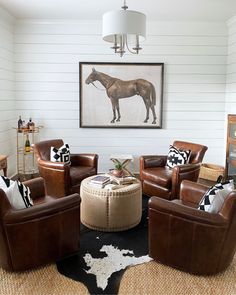 a living room filled with furniture and a horse painting on the wall above it's head