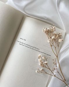 an open book with some flowers on top of it and a poem written in the middle