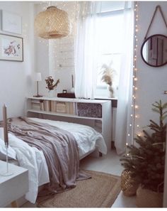 a bedroom decorated for christmas with lights on the windowsill and a bed in front