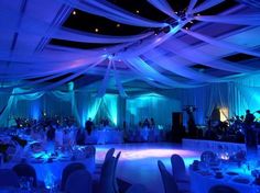 a banquet hall with blue lighting and white draping