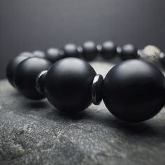 Adorn your wrist with our Men's Onyx Beaded Bracelet, a harmonious fusion of elegance and strength. This gemstone bracelet, featuring meticulously chosen Onyx beads, embodies a minimalist aesthetic that effortlessly complements the modern man's style. The 925 Sterling Silver detailing adds a touch of refinement, ensuring a timeless accessory that stands out. Crafted with a 6 and 8 mm bead arrangement, this stretch bracelet combines the natural allure of Onyx with the comfort of a durable stretch Modern Black Bracelets With 8mm Beads, Modern Black Bracelet With 8mm Beads, Modern Black Round Bead Bracelets, Minimalist Black Onyx Beaded Bracelets, Classic Black Onyx Bracelets, Classic Black Onyx Bracelet, Classic Black Bracelets With 8mm Beads, Minimalist Onyx Beaded Bracelets With Round Beads, Minimalist Onyx Beaded Bracelet With Round Beads