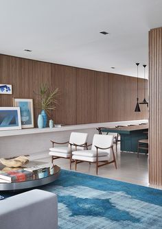 a living room filled with furniture next to a kitchen and dining room table on top of a blue rug