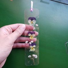 a hand holding a piece of plastic with flowers on it