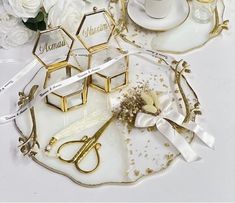 white and gold place setting with flowers on the table