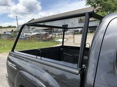 the back end of a pickup truck parked in a parking lot next to a building