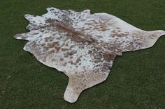 a brown and white spotted animal skin on grass