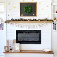 a fireplace decorated for christmas with garland and deer decorations