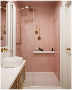 a bathroom with pink walls and gold fixtures