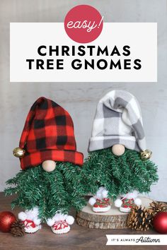 two christmas tree gnomes sitting next to each other on top of a wooden table