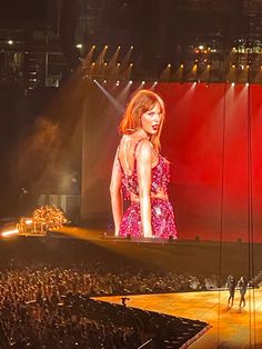 taylor swift performing on stage at a concert in front of a large group of people