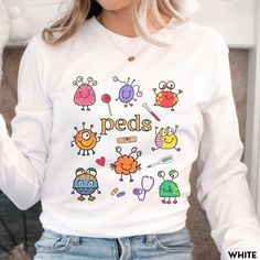 This Pediatric Nurse Shirt / Pediatric Doctor Long Sleeve Shirt is perfect for anyone in Pediatrics! Makes a great gift too!  **UNISEX SIZING**  Click this link for all of our Pediatric merchandise!  bit.ly/3HiNk3k ♥ W E L C O M E  T O  S K E T C H Y  C A T  D E S I G N S ! ♥ Click here to return to the shop home page ⇒ https://www.etsy.com/shop/SketchyCatDesigns Say hello to your new favorite shirt! These shirts are printed with eco-friendly water-based inks, giving them the softest feel. The design itself is embedded into the fabric so that your shirt is cozy and comfy. This design is featured on the Bella+Canvas Unisex Long Sleeve Jersey Tee. It's durable, yet lightweight, and just so soft! P R O D U C T  * Graphic is a high quality digital print which is durable and long lasting!  * 10 Graphic Print Long Sleeve Shirt As Gift, Fun Long Sleeve Tops, Long Sleeve Tops With Graphic Print, Casual Long Sleeve Shirt As Gift, Funny White Long Sleeve Tops, Fun Long Sleeve T-shirt For School, Cute Long Sleeve Shirt With Funny Print, Fun Long Sleeve School T-shirt, Funny White Long Sleeve Shirt