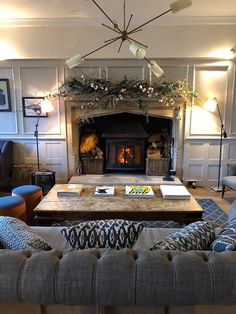 a living room filled with furniture and a fire place in the middle of it's wall