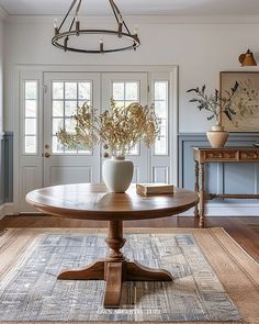 a dining room table with vases on top of it in front of two doors