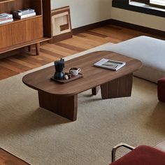 a living room with a couch, coffee table and bookshelf in the corner