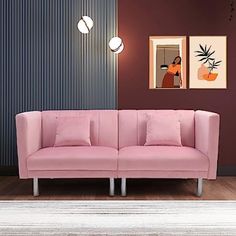 a pink couch sitting on top of a hard wood floor next to a white rug