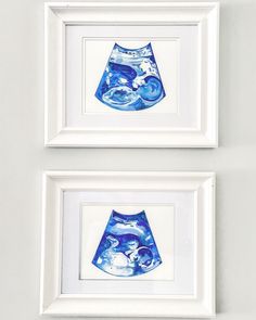 two framed pictures with blue vases on them