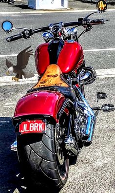 a red motorcycle parked next to a street