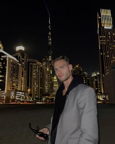 a man standing in front of a city at night