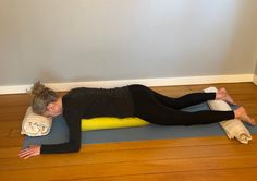 a woman is laying on her stomach while doing yoga