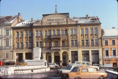 an old building with cars parked in front