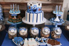 a blue and white dessert table filled with cookies